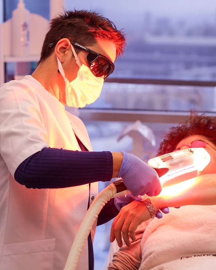 A woman receiving professional laser treatment from a specialist in a clinic setting.